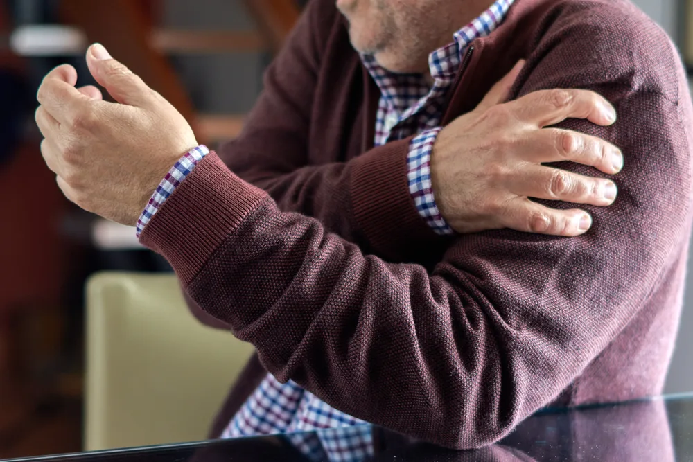 Homme âgé se tenant l’épaule douloureuse