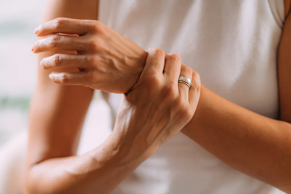 Femme se tenant le poignet, gêne articulaire